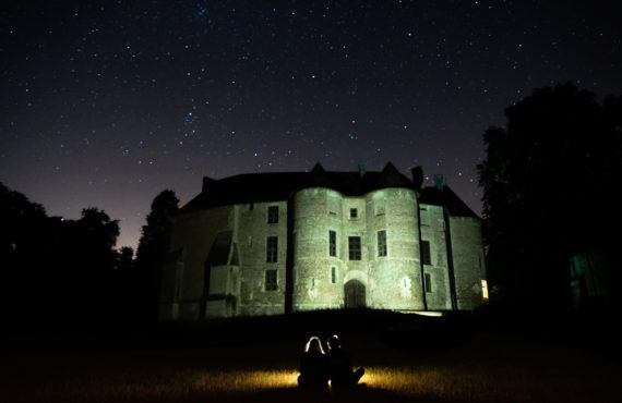 Chateau d'harcourt eclairé avec deux personnes en ombre devant