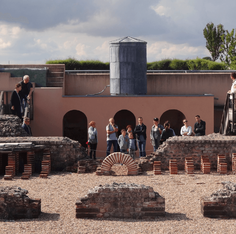 groupe de personnes devant des vestiges archéologiques