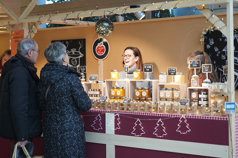 stand avec deux clients et des pots de miel