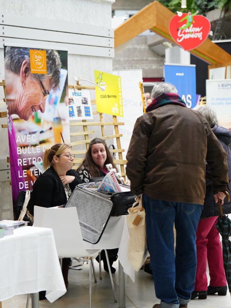 personnes en train de discuter à un stand