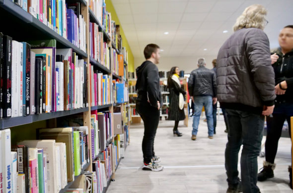 Plusieurs personnes devant un rayonnage de livres