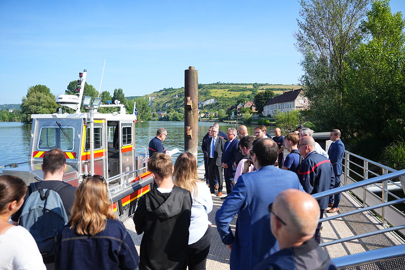 54597973518_028bf4a03b_c groupe de personnes sur un ponton devant une rivière et un bateau