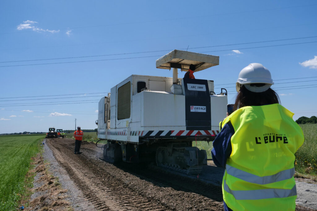 RD547-1 personnes avec un gilet jaune et une grosse machine devant elle