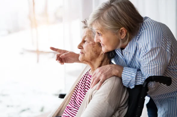 Personne âgée dans un fauteuil et aidant